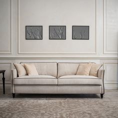 a white couch sitting in front of two framed pictures