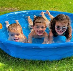 three children are playing in the pool with their swimming goggles on and one child is smiling at the camera