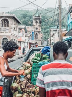 two men unloading produce from the back of a truck