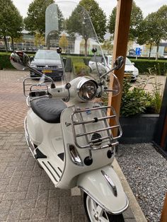 a white scooter parked next to a wooden pole