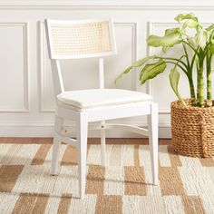 a white chair sitting next to a potted plant