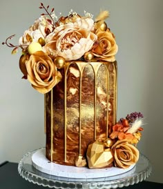 a golden cake with flowers and feathers on top