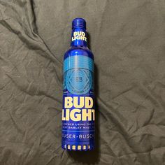 a bottle of bud light sitting on top of a bed