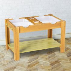 a wooden table with two trays on the top and one shelf below it that holds bowls