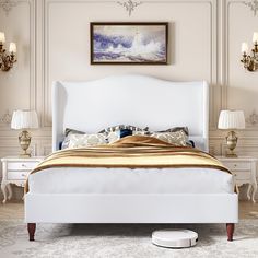 a white bed sitting in a bedroom on top of a hard wood floor next to two lamps