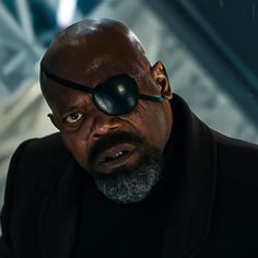 a man with an eye patch on his face looking at something in front of him