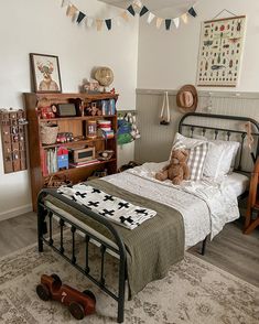 a bedroom with a bed, bookshelf and teddy bear on the floor in it