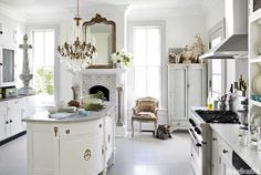 a kitchen with white cabinets and an ornate chandelier