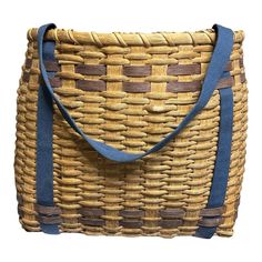 a brown and blue woven bag on a white background with strap around the bottom of it