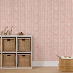 an empty room with pink wallpaper and wicker baskets on the floor next to it