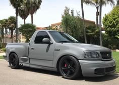 a silver truck parked in front of palm trees