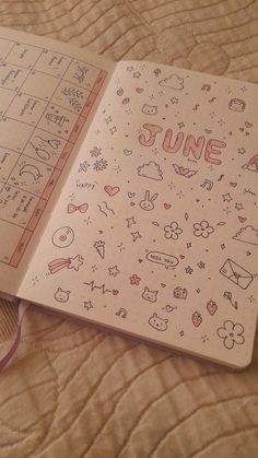 an open notebook with doodles on it sitting on a bed next to a fan