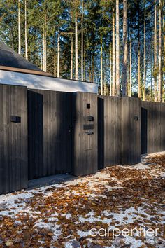 a row of wooden stalls sitting next to each other on top of snow covered ground