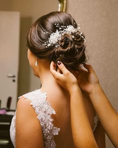 a woman in a wedding dress fixing her hair