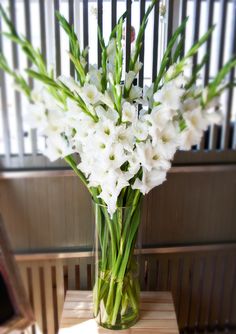 a vase filled with white flowers on top of a wooden table