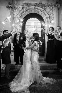 a bride and groom are surrounded by sparklers as they walk down the aisle at their wedding