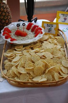 a platter filled with chips and dips next to a plate of crackers