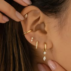 a close up of a person's ear with three piercings