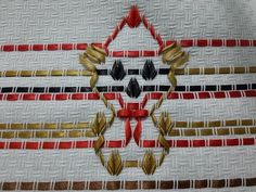 a close up of a piece of cloth with gold, red and black designs on it