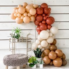 balloons are stacked on top of each other in front of a white wall and chair