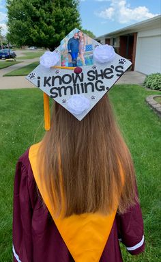 a woman wearing a graduation cap with the words i know she's smiling on it