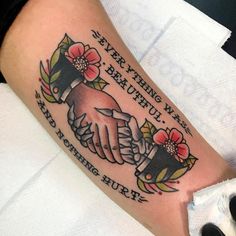 a couple of hands holding each other on top of a white sheet with words and flowers