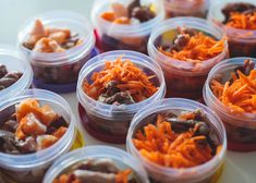 several plastic containers filled with different types of food items on top of a white table