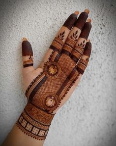 a hand with henna on it that is painted brown and has an intricate design