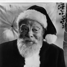 an old black and white photo of a man wearing a santa hat