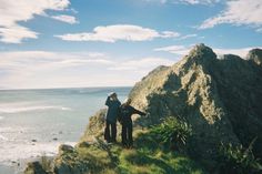 two people standing on the edge of a cliff