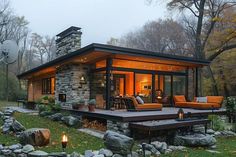 a small house with stone and wood sidings in the evening time, surrounded by trees