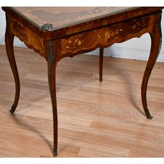 an antique wooden table sitting on top of a hard wood floor