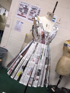 a dress made out of newspapers sitting on top of a mannequin