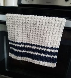 a white and blue dish towel hanging on the oven door