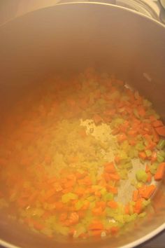 a pot filled with carrots and other vegetables on top of a stove burner