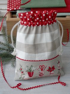 a small bag with red and white polka dot trimmings sitting on top of a table