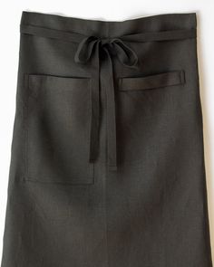 a woman's black skirt with a tie at the waist and pockets on the side