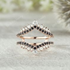 two rings with black and white stones on them, one is shaped like an upside down triangle