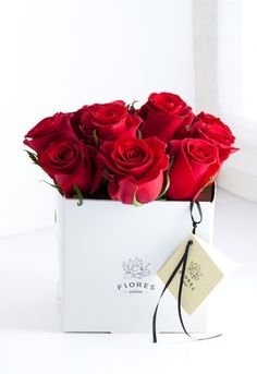 a bouquet of red roses in a white box