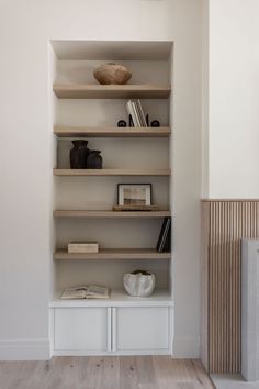 an empty shelf in the corner of a room with books and other items on it