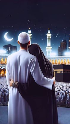 a man and woman embracing in front of an illuminated mosque