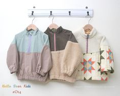 three jackets hanging on a clothes rack next to each other