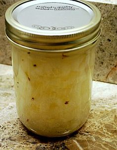 a glass jar filled with food sitting on top of a counter next to a tile wall