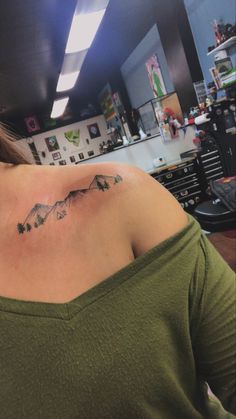 a woman with a mountain tattoo on her shoulder