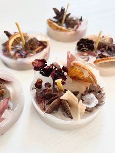 four bowls filled with food on top of a white table