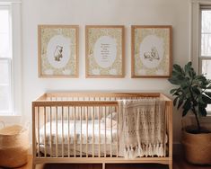 a baby's room with three framed pictures on the wall and a crib