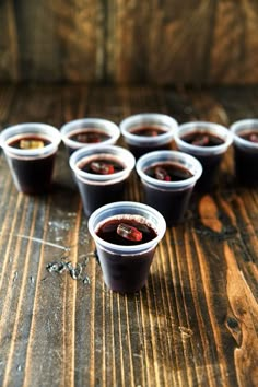 small plastic cups filled with liquid on top of a wooden table