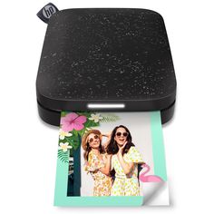 an image of two women in front of a photo on a polaroid print printer