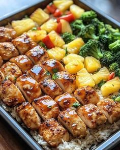 chicken, pineapples and broccoli on top of rice in a pan