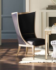 a black and white chair sitting in front of a mirror on top of a wooden floor